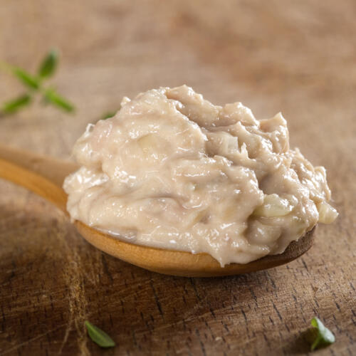 Spoon filled with creamy paste made from tone fish, butter and o