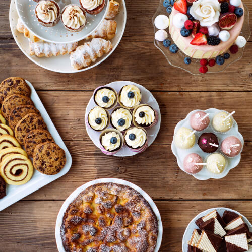 Table with cake, pie, cupcakes, cookies, tarts and cakepops